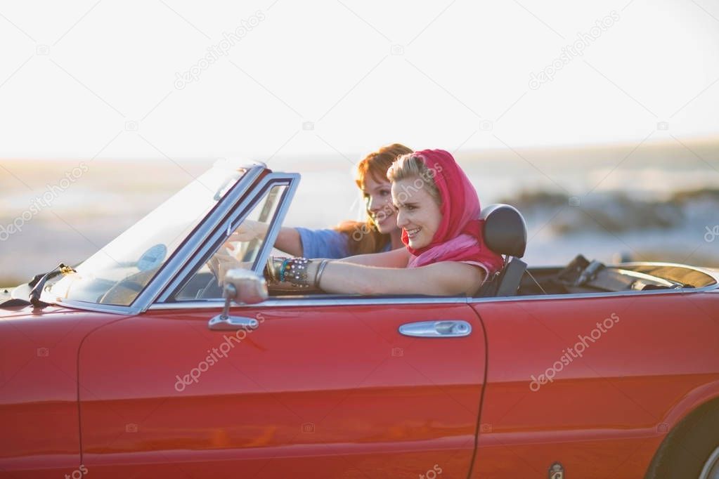 two smiling women driving