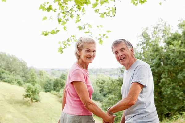 Senior Adult Caucasian Couple Holding Hands Looking Back — Stock Photo, Image