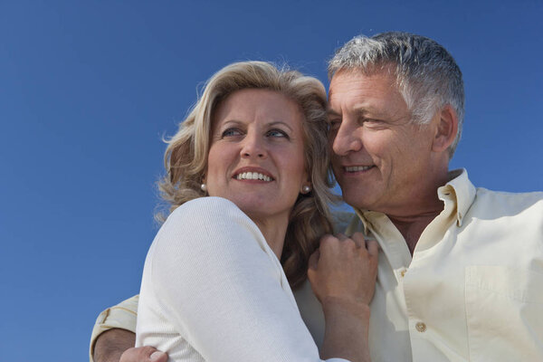 caucasian mature adult couple embracing and smiling