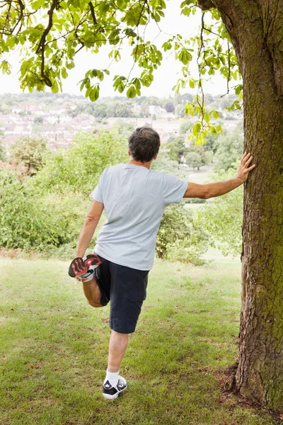 年配の白人男性が公園に足を伸ばす — ストック写真