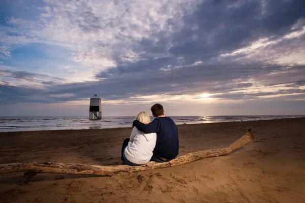 年轻漂亮的白种情侣在沙滩上看日落 — 图库照片
