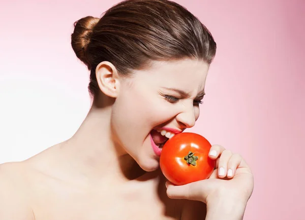 Bela Caucasiano Jovem Mulher Comer Tomate Contra Fundo Rosa — Fotografia de Stock