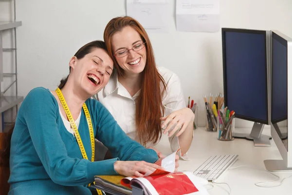 Besdie のオフィスのコンピューターで笑って二人の白人魅力的な女性 — ストック写真