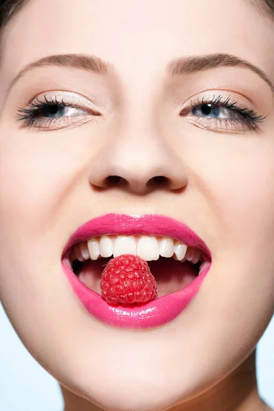 ラズベリーを食べて笑顔の美しい白人若い女性 — ストック写真