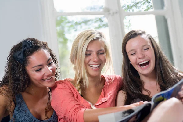 Dziewczyny Śmieją Się Patrząc Magazyn — Zdjęcie stockowe