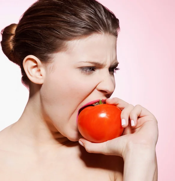 Bela Caucasiano Jovem Mulher Comer Tomate Contra Fundo Rosa — Fotografia de Stock