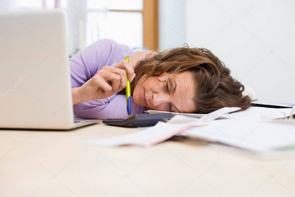 Desperate housewife lying on table with laptop and frustrating