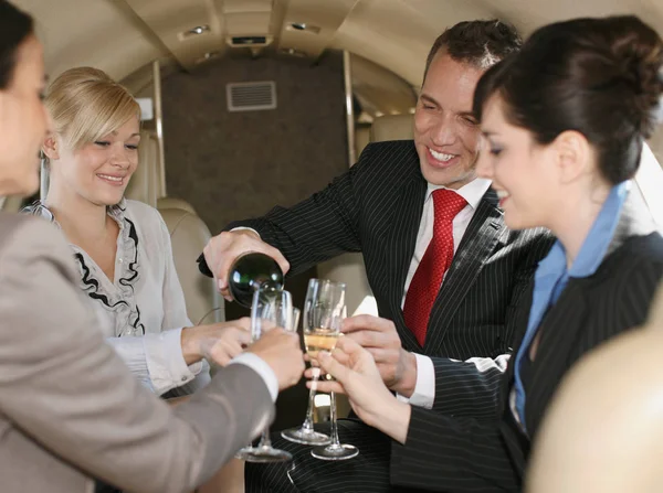 Business people celebrating in plane