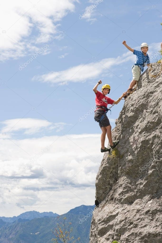 two boys climbing in mountains 