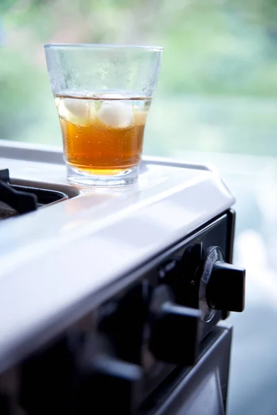 Glass of iced tea on stove — 스톡 사진