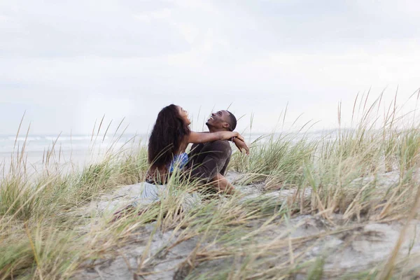 Un couple se trompe dans les dunes de sable, riant — Photo