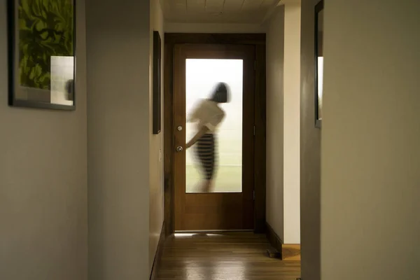 Silhouette of businesswoman closing front door — Stock Photo, Image