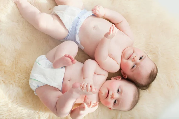 Tweeling Baby Meisjes Liggend Een Schapenvacht Tapijt — Stockfoto