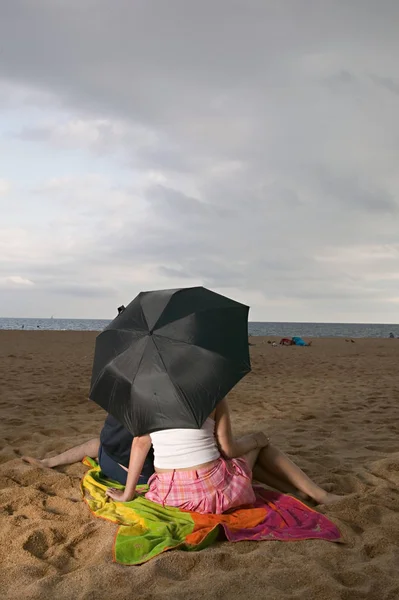 ビーチに傘のカップル — ストック写真