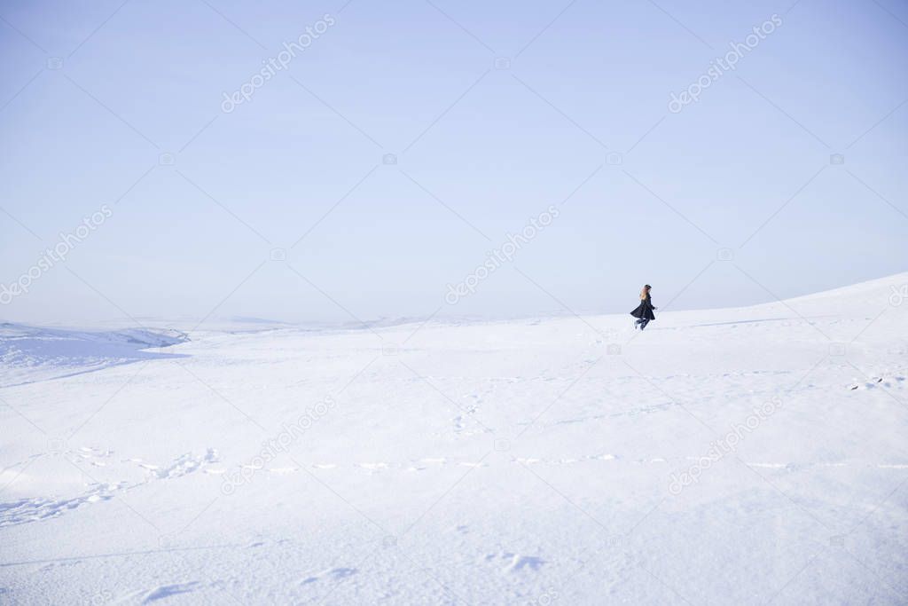 Young girl walking in snowy landscape