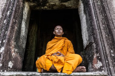Genç Budist keşiş Angkor Wat, Siem Reap, Kamboçya 'daki tapınakta meditasyon yapıyor.