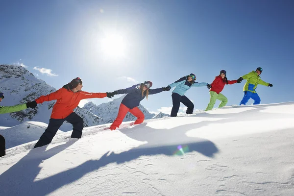 雪の中で互いの上り坂を引く友人,クタイ,オーストリア — ストック写真