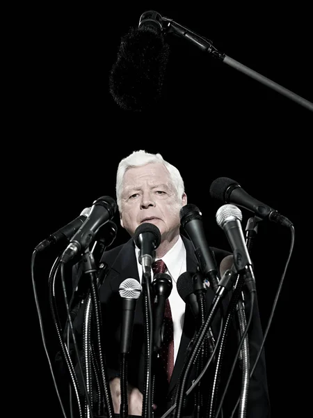 Politician and microphones isolated on black background