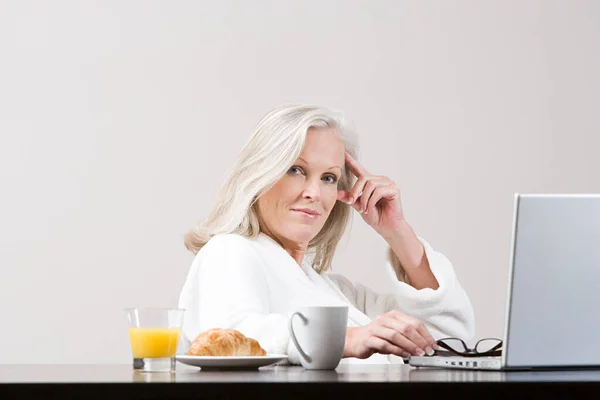 Mujer Mediana Edad Utilizando Ordenador Portátil Hora Del Desayuno —  Fotos de Stock