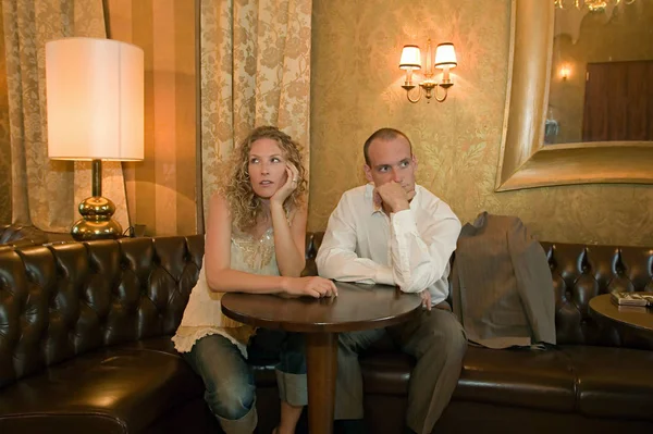 Couple in a bar ignoring each other