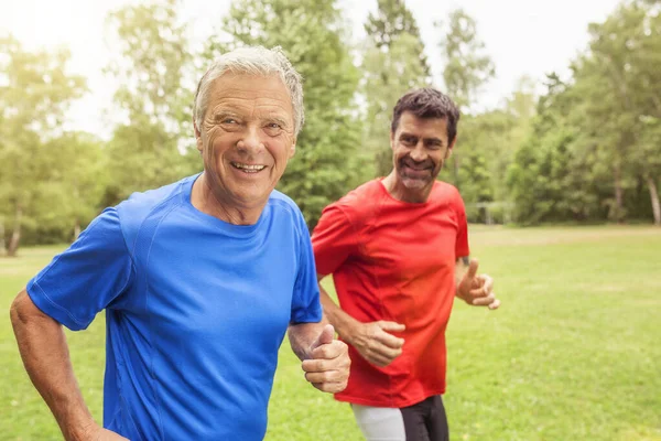 Two men running outdoors, smiling