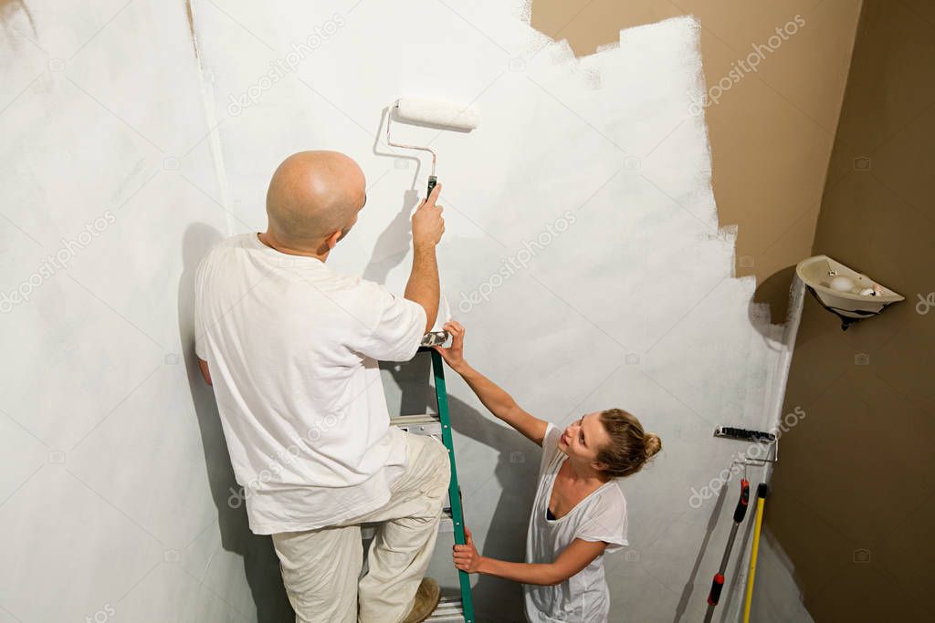 Couple painting wall close up