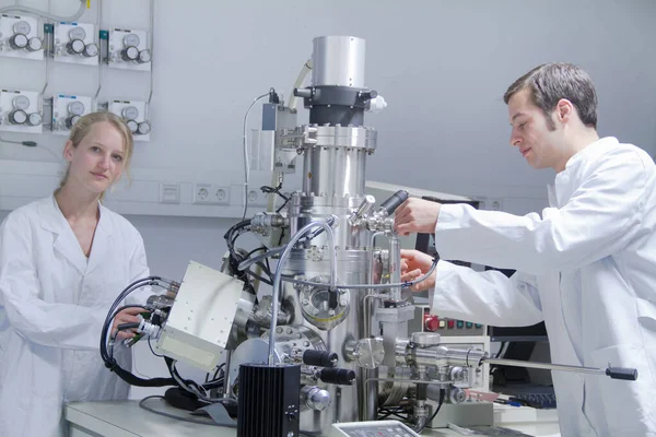 Δύο Επιστήμονες Που Φορούν Εργαστηριακές Ποδιές Χρησιμοποιώντας Επιστημονικό Εξοπλισμό — Φωτογραφία Αρχείου