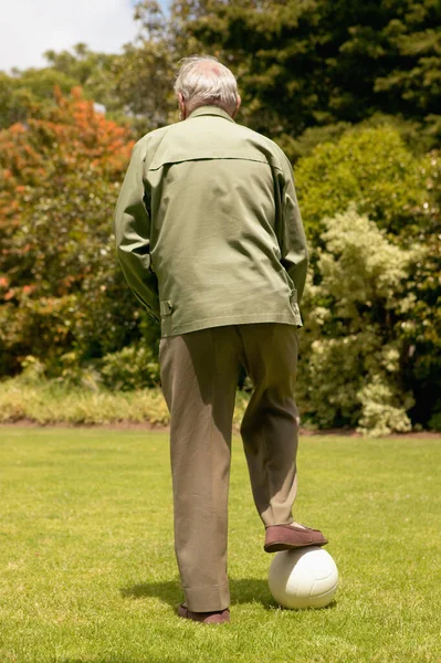 Rear view of a senior man with a football