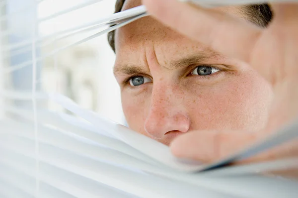 close-up portrait of Businessman looking through blinds