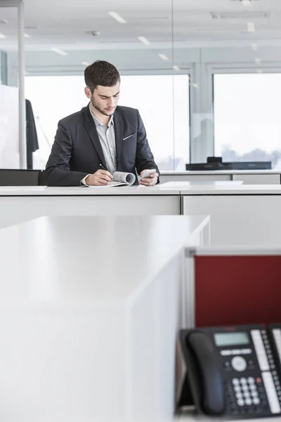 Empresario Pie Oficina Leyendo Papeleo Utilizando Teléfono Inteligente — Foto de Stock