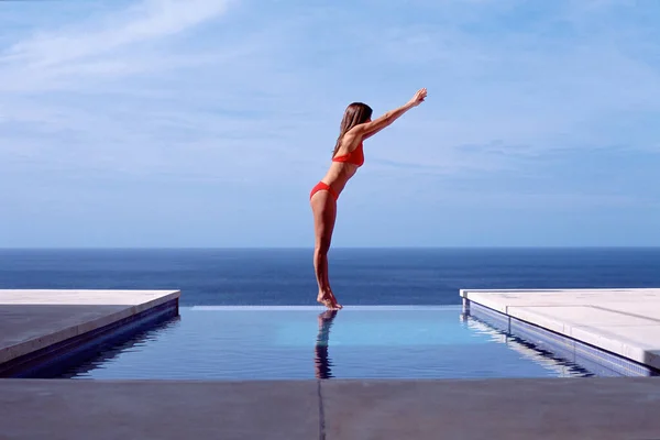 Young woman at swimming pool by the sea