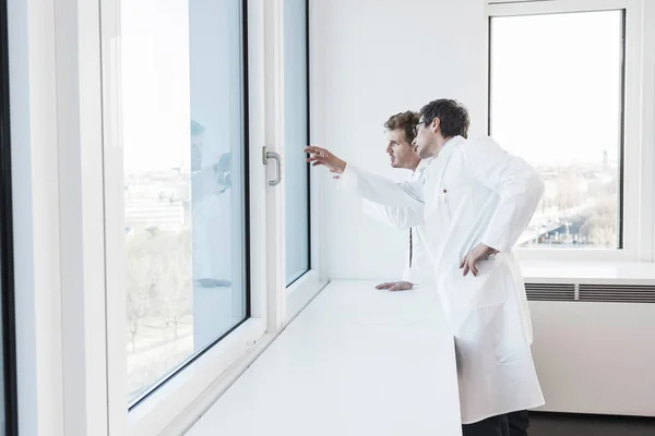 Laborköpenyes Férfiak Néztek Ablakon Mutogattak — Stock Fotó