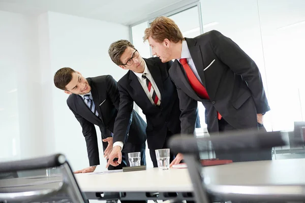 Les Hommes Affaires Penchés Sur Table Conférence Pointant Vers Paperasserie — Photo