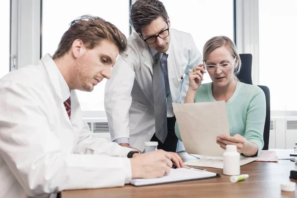 Homens Vestindo Casacos Laboratório Mulher Sentados Mesa Fazendo Papelada — Fotografia de Stock