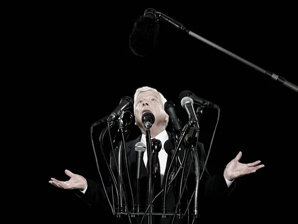 Politician and microphones isolated on black background