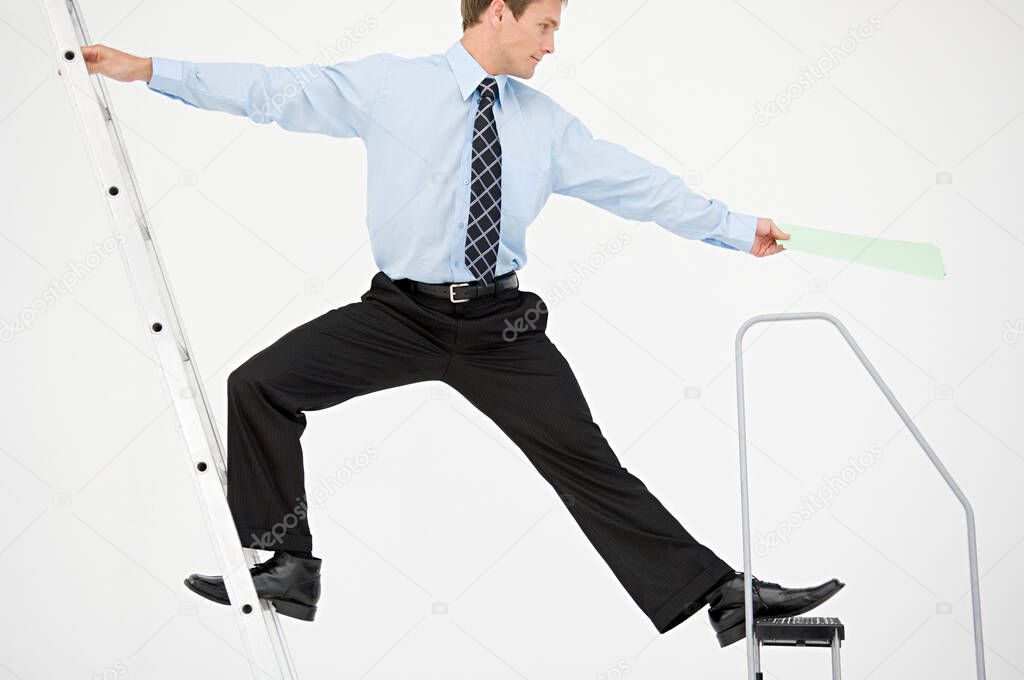 Businessman balancing on two ladders