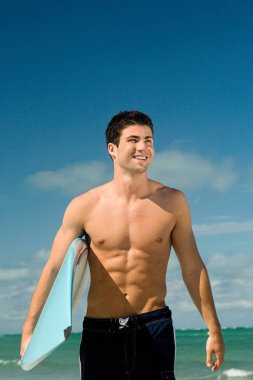 Sörf tahtası olan genç adam