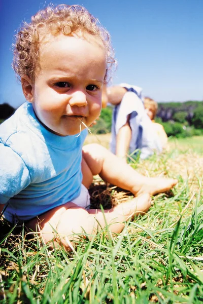 Toddler Eating Grass Sky — kuvapankkivalokuva