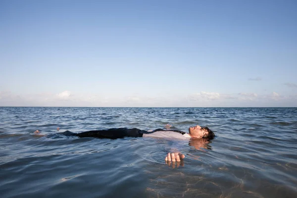 Businessman floating in sea water