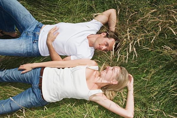 一对年轻夫妇躺在田里 — 图库照片