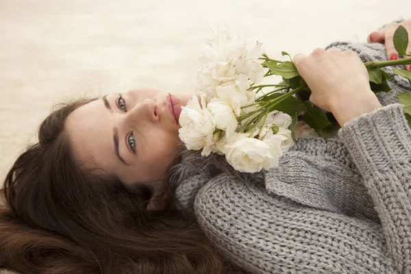 Junge Frau Liegt Auf Teppich Und Hält Weiße Blumen Der — Stockfoto