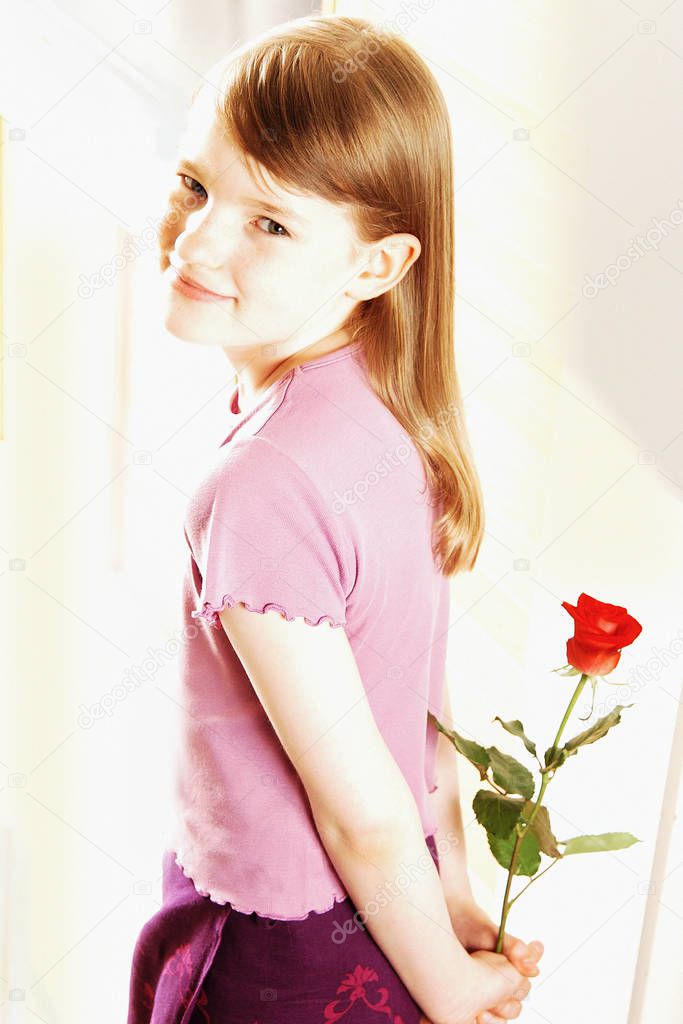 Smiling girl holding red rose