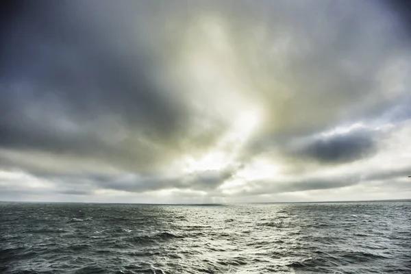阳光反射在水面上的大海和暴风雨般的天空 — 图库照片