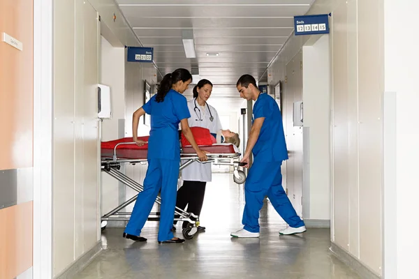 Doctors with patient on hospital trolley