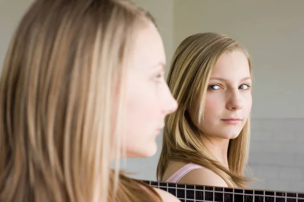 A teenage girl looking in a mirror