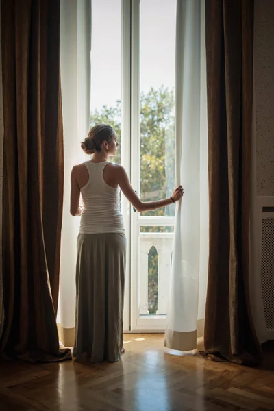 Elegante Giovane Donna Che Guarda Fuori Dalle Finestre Del Salotto — Foto Stock