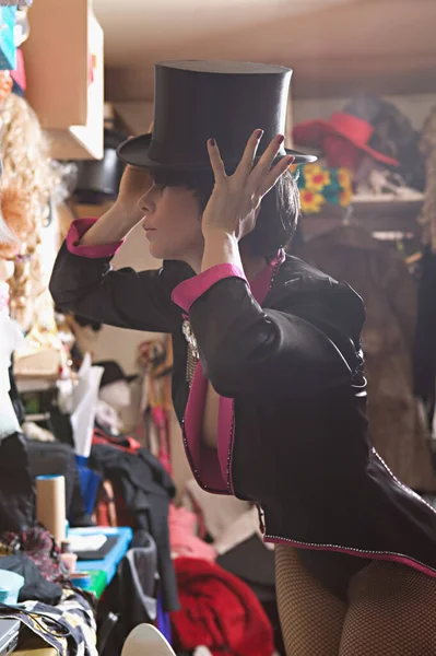 Performer adjusting her top hat