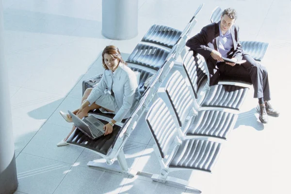 Businessman and businesswoman meeting in airport lounge