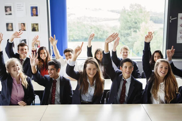 在课堂上举手的十几岁学童 — 图库照片