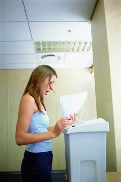 An office worker having an accident with a paper shredder